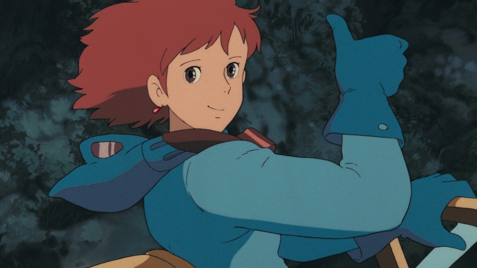 Nausicaä, her helmet and mask removed, which is dangerous in the situation she is in, her short red hair blowing in the wind. Nevertheless, she looks at the viewer with bright brown eyes, a smile, and a thumbs-up gesture.