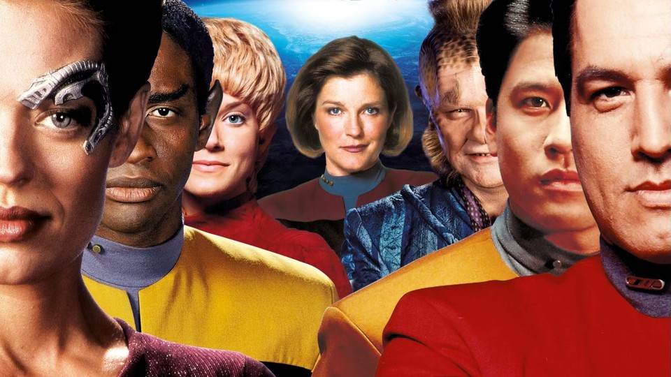 Closeups of the crew, from left: Seven of Nine, white Borg/human blonde woman with a metallic implant above her eye; Tuvac, dark-haired dark-skinned Vilkan; Kes, white blonde Ocampa woman; Kathryn Janeway, brown-haired white woman; Neelix, Talaxian man with a mixture of cat-like and lizard-like features: leathery skin, spots around his face, fur-like hair and sideburns; Harry Kim, dark-haired Asian man; Chakotay, dark-haired indigenous man from Central America.