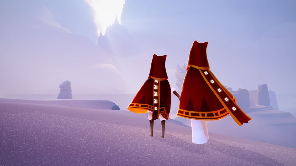 Two characters wearing red ponchos, hoods and scarves with gold trim and white symbols, similar to the clothes worn by characters in the game Journey. They are standing in a glittering, magical-looking desert, looking at a silhouette of a distant castle hidden in the clouds.